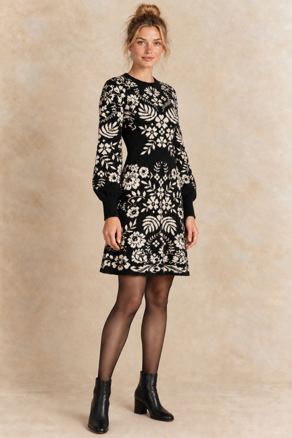 Léonie black and ivory botanical knit dress three-quarter view with semi-opaque tights and black ankle boots.