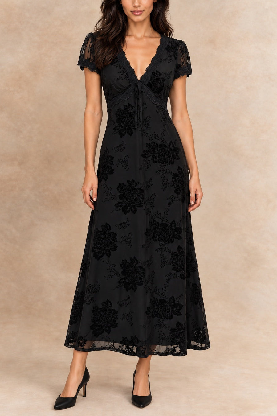 Bérénice black floral dress with lace-trimmed V-neck and short sleeves, front view on Inès with black heels.